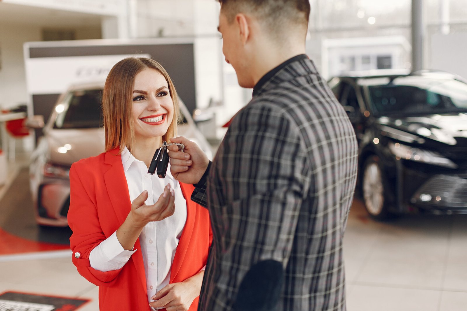 Couple in a car salon. Family buying the car. Elegant woman with her boyfriend.